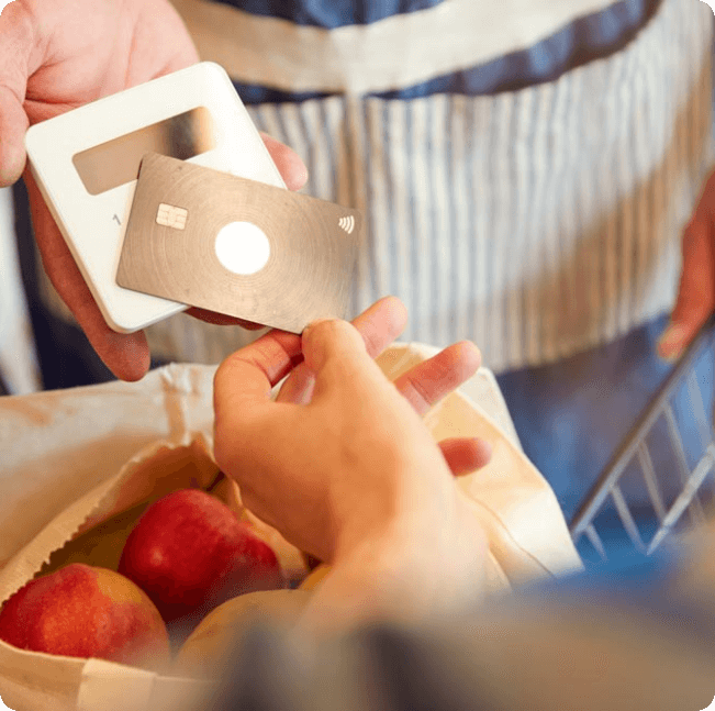 Verkäufer kassiert Äpfel mit einem Kartenterminal
