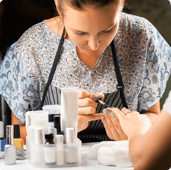 Frau lässt sich in Nagelstudio die Nägel lackieren